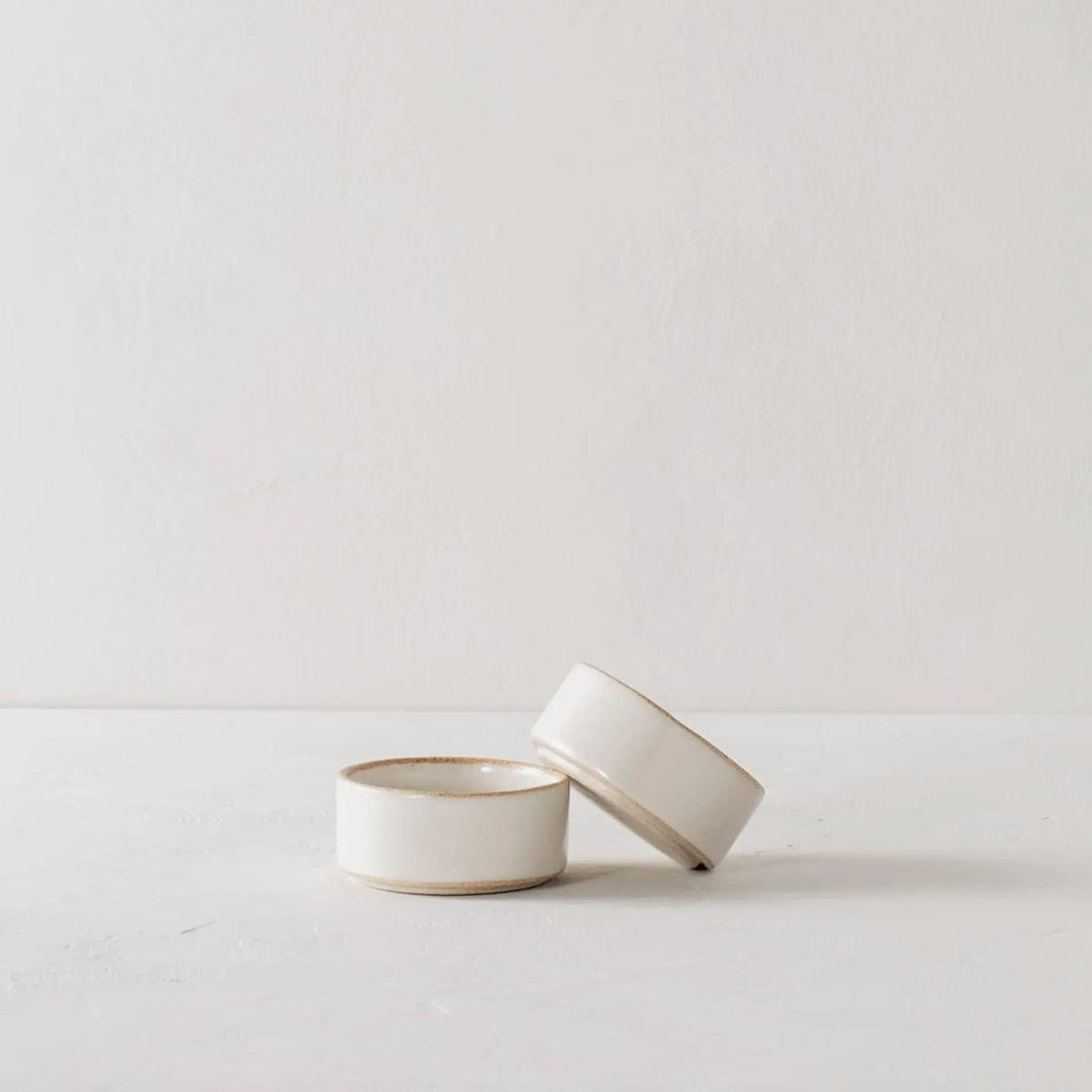 Two mini ceramic ramekins sit stacked next to each other, made of sand stoneware and finished in an ivory glaze