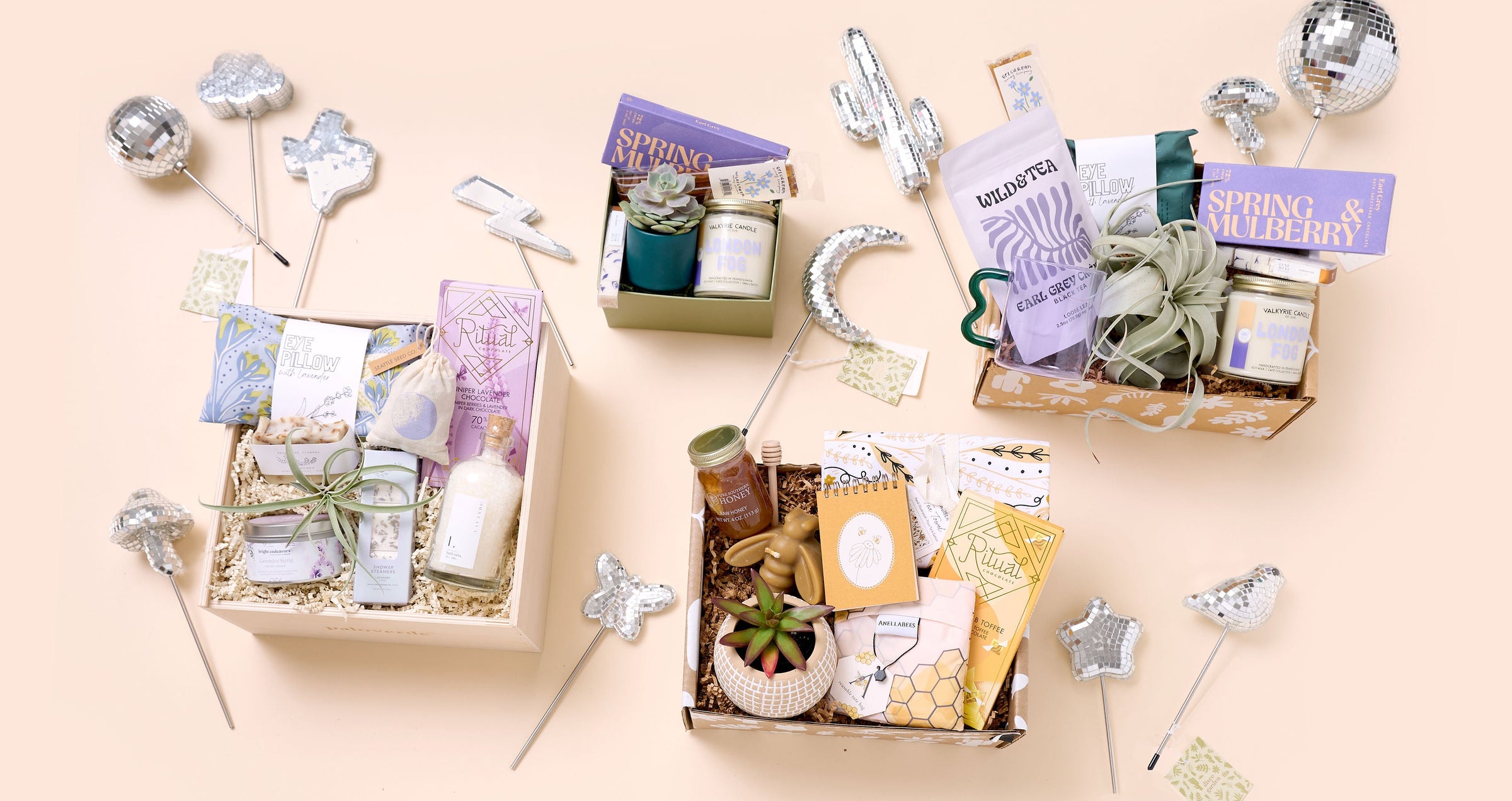 Collection of plant gift boxes with decorative disco plant stakes on a beige background