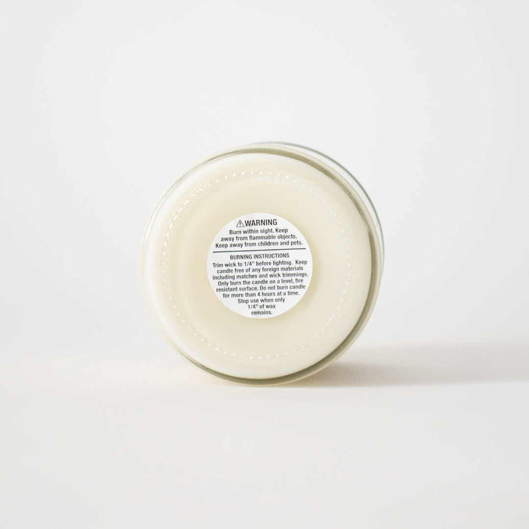 Round candle with a label on a white background