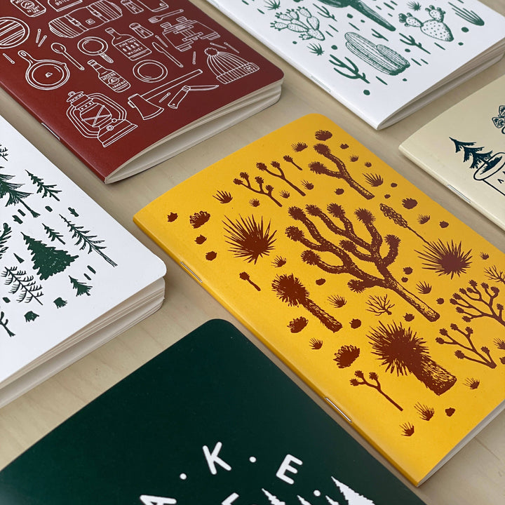 Set of notebooks with various designs on a wooden surface